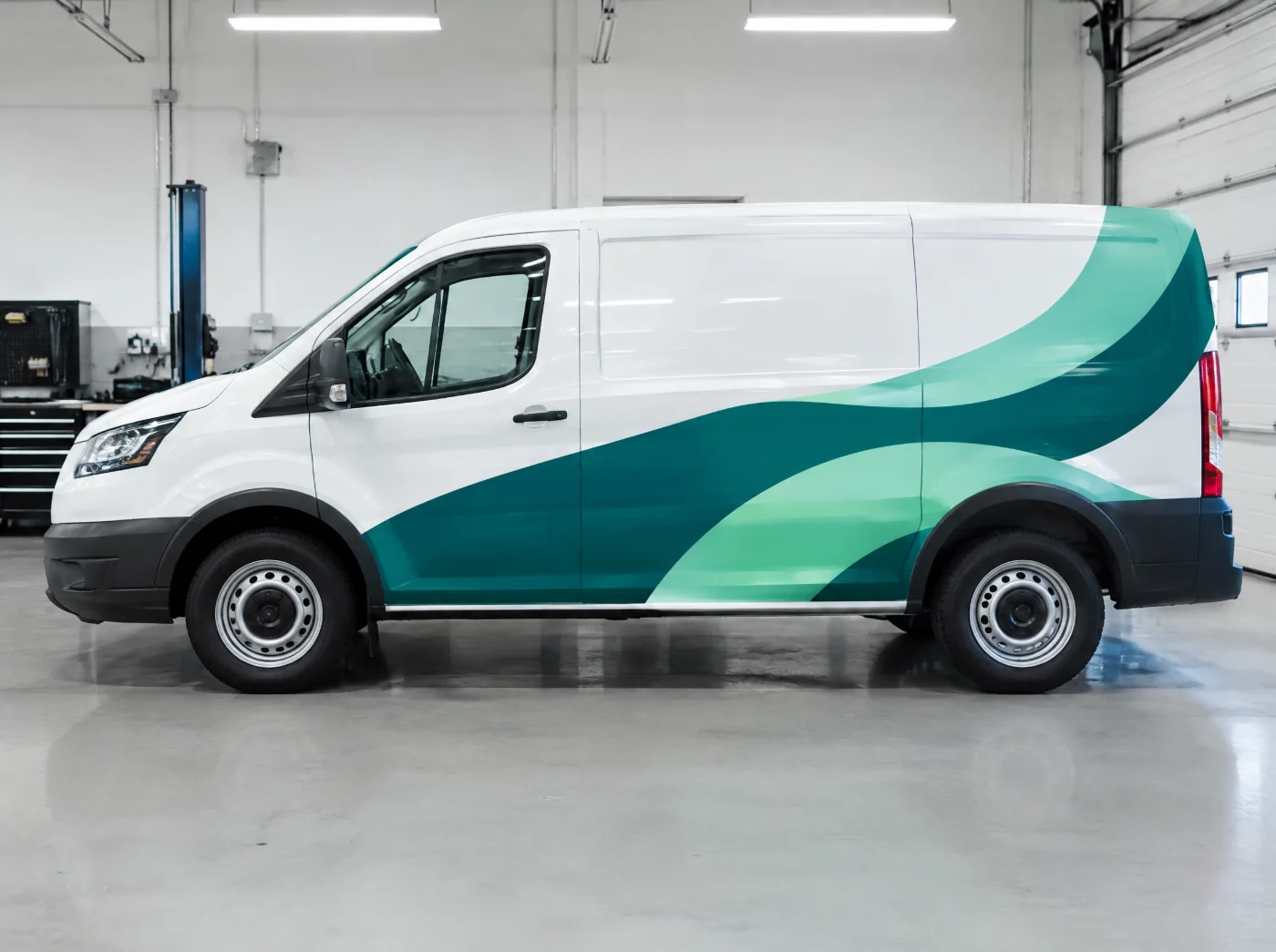 Pakettiauto turkoosilla mainosteippauksella